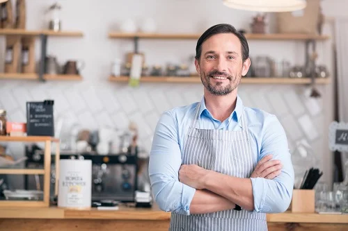 Coffee shop owner happy in his coffee shop